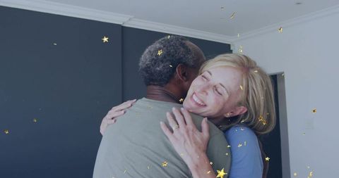 Mature couple embracing amid gold confetti celebrating love, joy and renewed commitment