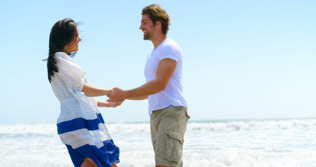 Happy caucasian couple holding hands on beach, copy space. Relationship, togetherness, summer, leisure, vacation and lifestyle, unaltered.