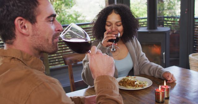 Smiling biracial couple drinking wine and having lunch at a restaurant - Download Free Stock Photos Pikwizard.com