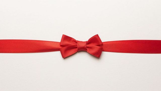 Red satin ribbon with small bow centered on white background for gift wrapping and greeting cards