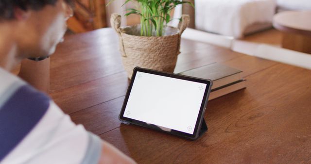 Person Using Tablet on Wooden Desk Near Potted Plant - Download Free Stock Images Pikwizard.com