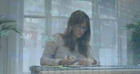 Businesswoman Analyzing Financial Data with Market Trends Overlay