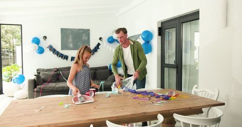 Father and Daughter Tidying After Birthday Celebration in Bright Room