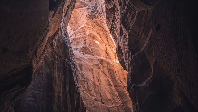 Sunlit slot canyon revealing layered sandstone strata and dramatic light-and-shadow