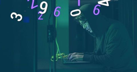 Hooded hacker typing on laptop with floating digits in server room