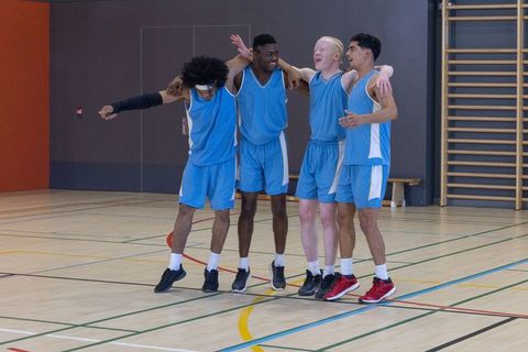 Diverse Male Athletes Celebrating Teamwork on Basketball Court