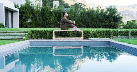 Woman in Relaxation Moment by Peaceful Poolside in Tranquil Setting