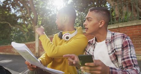 Two Friends Navigating with Map and Smartphone on Vacation