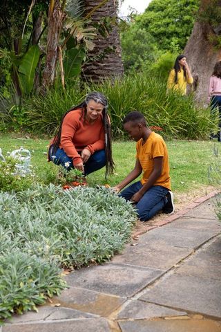 Mother and son bonding through gardening in lush outdoor setting