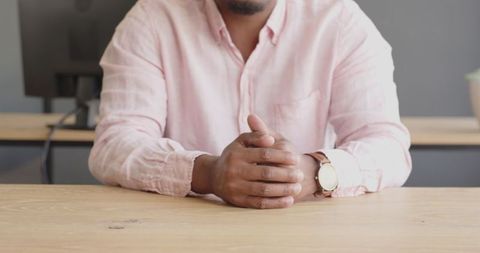 Businessman in Pink Shirt with Watch Sitting at Desk During Office Meeting - Download Free Stock Images Pikwizard.com