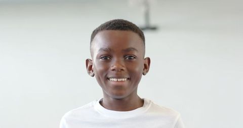 Cheerful boy smiling in minimalist interior setting