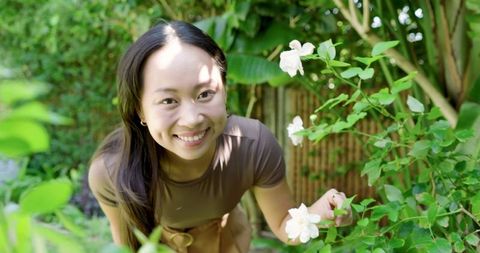 Woman in Garden Enjoying Blooming Flowers