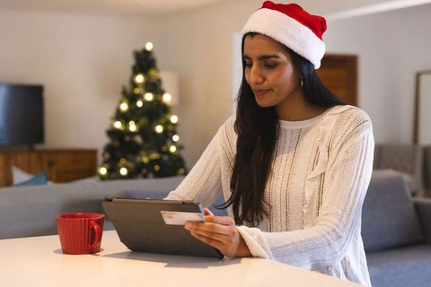 Woman Wearing Santa Hat Online Holiday Shopping on Tablet
