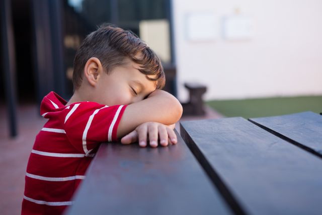 Close up of boy sleeping on table at school