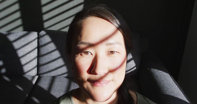 Woman Smiling in Sunlight with Shadow Patterns on Face - Download Free Stock Images Pikwizard.com