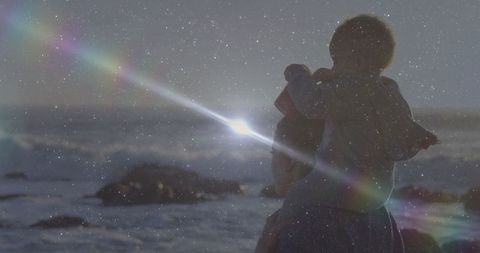 Mother and Child Bonding at Rocky Ocean Shoreline with Dreamy Light