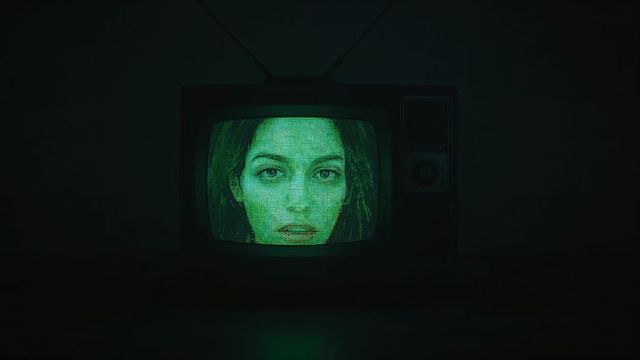Retro CRT TV Displaying Female Face with Glowing Green Screen