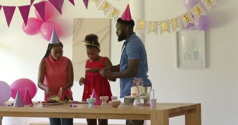 Family Celebrating Birthday at Home with Cake and Decorations