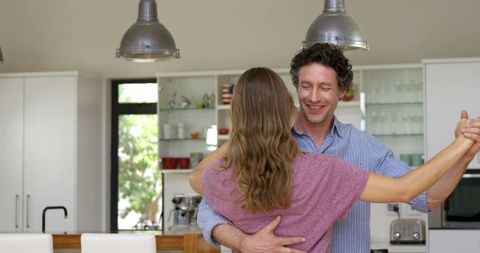 Happy Couple Joyfully Dancing in Modern Kitchen