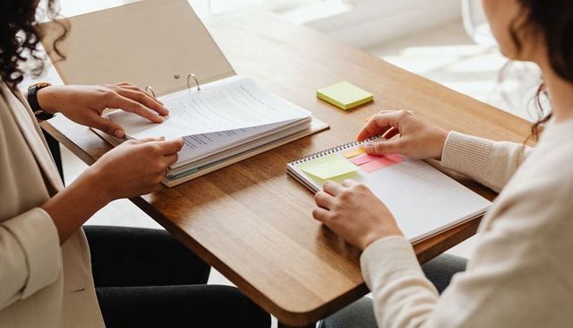 Reviewing documents and planning with notebook and sticky notes in collaborative office