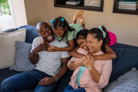 Diverse Family Laughing Together on Living Room Sofa
