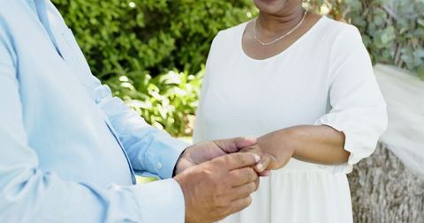 Senior Couple Exchanging Rings in Romantic Garden Ceremony