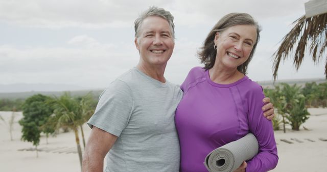 Happy Senior Couple Embracing at Beach with Yoga Mat - Download Free Stock Images Pikwizard.com