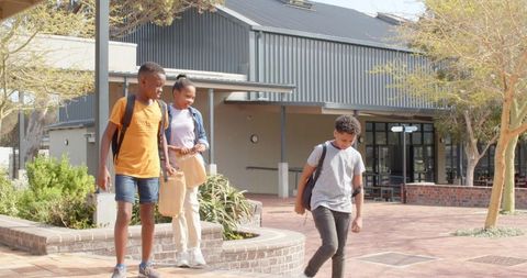 Diverse Students Walking in School Courtyard with Backpacks