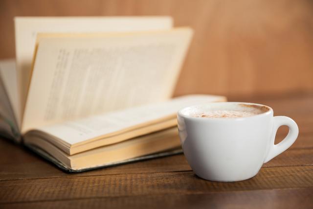 Close-Up of Coffee Cup and Open Book on Wooden Table - Download Free Stock Photos Pikwizard.com