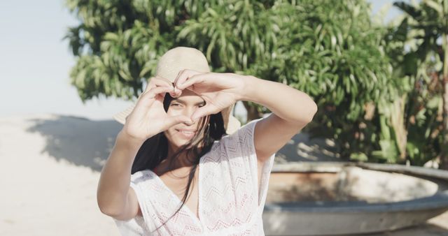 Smiling Woman Creating Heart Shape with Fingers Outdoors - Download Free Stock Images Pikwizard.com