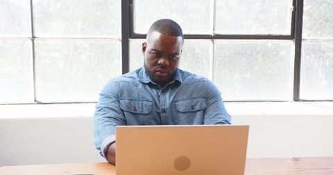 Businessman Thinking at Workspace with Laptop in Bright Office