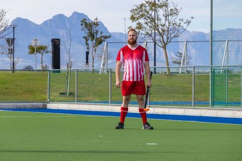 Field hockey player standing on synthetic turf at sports complex