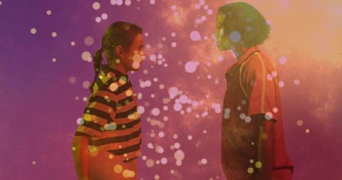 Two women facing each other and standing in colorful bokeh haze studio portrait