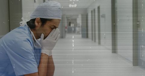 Stressed Healthcare Worker in Hospital Corridor with Static Overlay