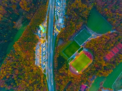 Autumn aerial capture showing illuminated highway rest area and glowing sports fields