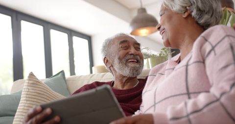 Elderly Couple Laughing Together with Tablet in Comfortable Living Room - Download Free Stock Images Pikwizard.com