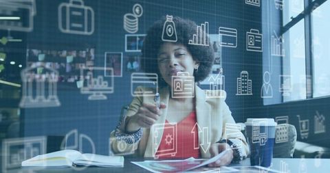 Businesswoman pointing at documents while reviewing digital data overlay in modern office