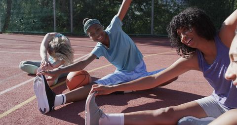 Diverse Female Basketball Team Enjoying Stretch on Court