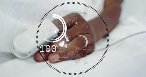 Patient hand wearing pulse sensor showing hud 100 biometric overlay on hospital bed