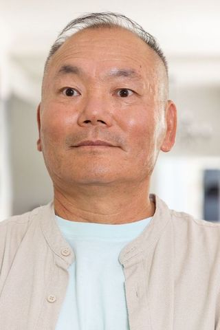 Senior asian man looking upward in soft window light, calm contemplative portrait