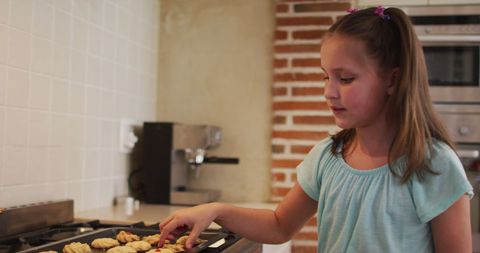 Caucasian Girl Enjoying Freshly Baked Cookies in Home Kitchen