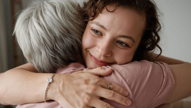 Young woman hugging senior with warm smile, intimate family embrace and tenderness