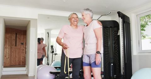 Senior lesbian couple enjoying fitness routine at home gym