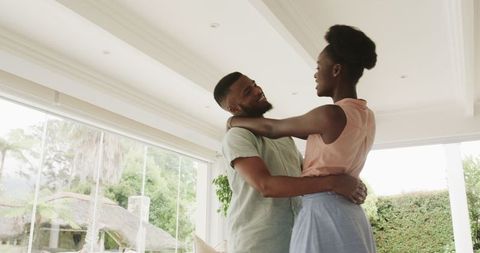 Young Couple Dancing Joyfully in Living Room During Daytime