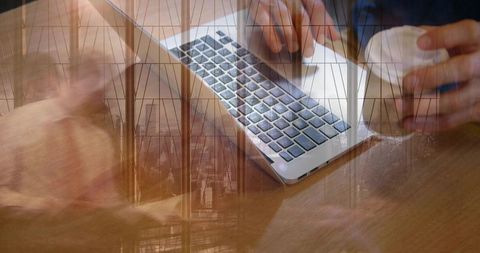 Hands Typing on Laptop While Holding Coffee Cup with Glass Window and City Double Exposure