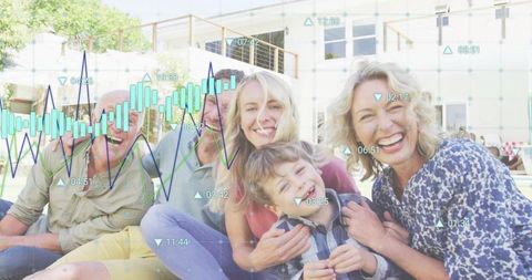 Multi-generational family sitting and smiling in backyard with digital analytics data overlay