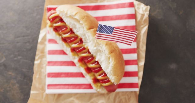 Image of hot dog with mustard and ketchup with flag of usa on a black surface. food, cuisine and catering ingredients.