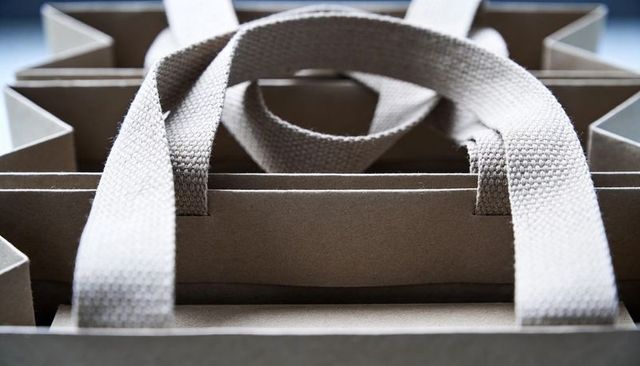 Stacking kraft paper shopping bags with woven cotton handles and neutral packaging texture