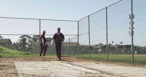 Baseball players walking on bullpen mound in team uniforms