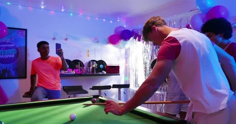 Late-night pool party friends playing billiards under neon lights and retro disco decor